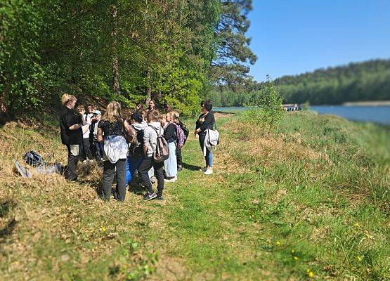Praktyczna nauka rozpoznawania ryb Praktyczna nauka rozpoznawania ryb przez grupę osób zgromadzonych na polanie nad jeziorem
